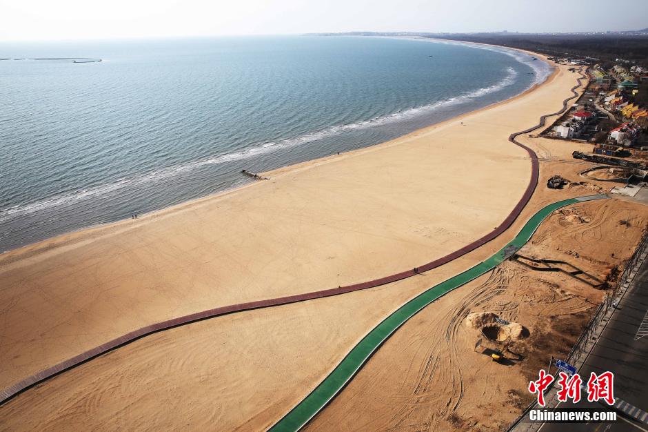 3月13日，秦皇島萬(wàn)米臨海沙灘木棧道。據(jù)了解，該木棧道全長(zhǎng)約4200米，與北戴河區(qū)原有的7500米木棧道對(duì)接后全線總長(zhǎng)度1.17萬(wàn)米，整個(gè)木棧道東起秦皇島體育基地游船碼頭，西至北戴河濕地公園，呈波浪形蜿蜒10.4公里海岸線。 中新社發(fā) 曹建雄 攝 CNSPHOTO